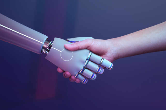 an image of human and a robot shaking hands